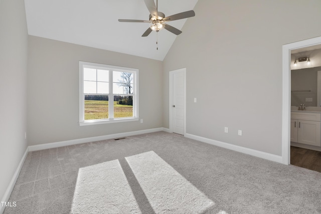 spare room with light carpet, high vaulted ceiling, and ceiling fan