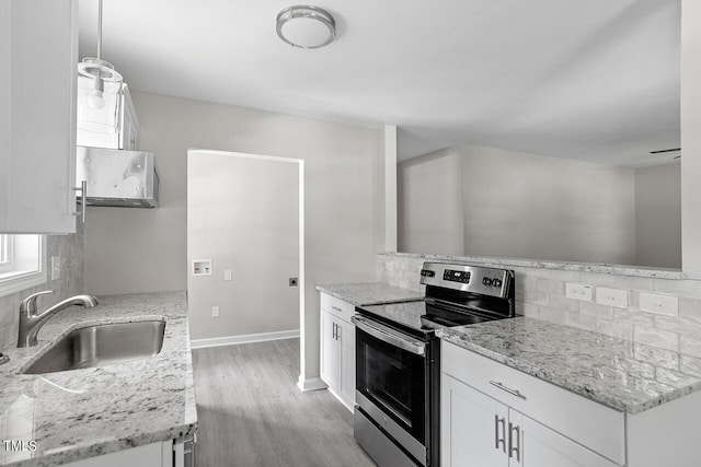 kitchen with pendant lighting, light hardwood / wood-style flooring, sink, stainless steel electric range, and white cabinetry