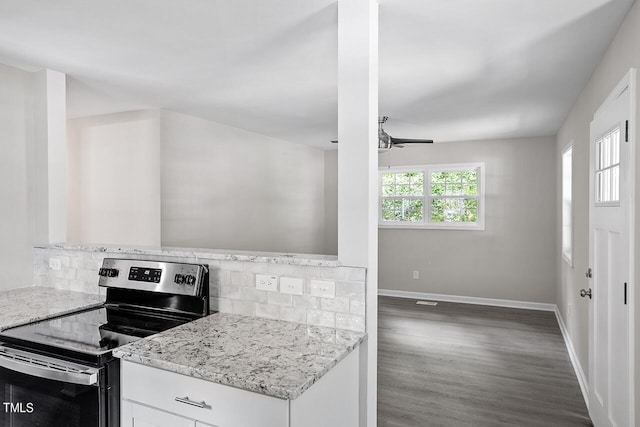 kitchen with white cabinets, stainless steel electric range, light stone countertops, dark hardwood / wood-style flooring, and decorative backsplash