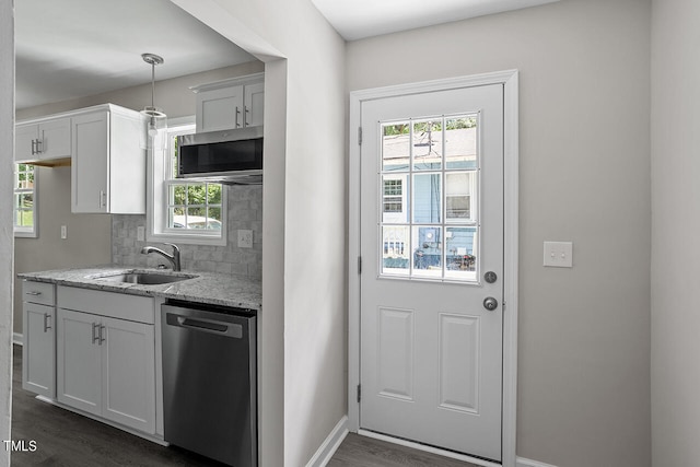 kitchen featuring appliances with stainless steel finishes, hanging light fixtures, white cabinetry, and sink