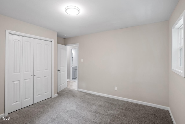 unfurnished bedroom with a closet and light carpet