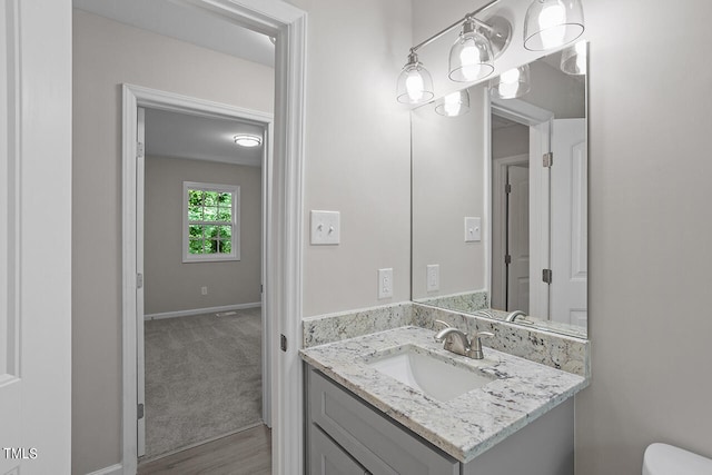 bathroom with vanity, hardwood / wood-style floors, and toilet