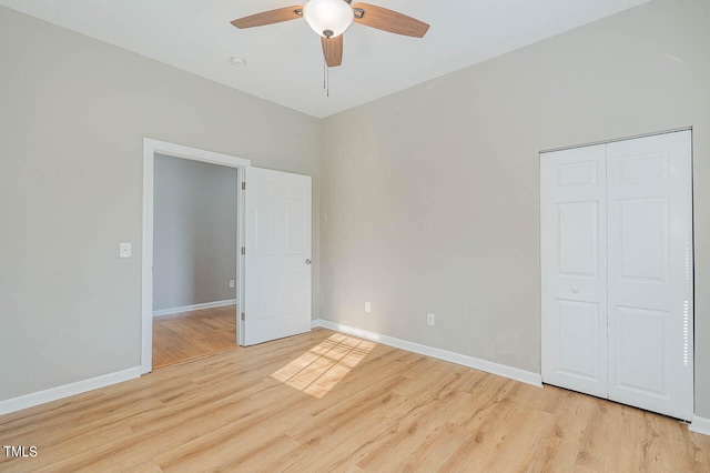 unfurnished bedroom with ceiling fan, light wood-type flooring, and a closet