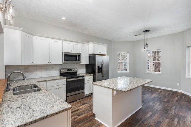 kitchen featuring white cabinets, sink, a kitchen island, and stainless steel appliances