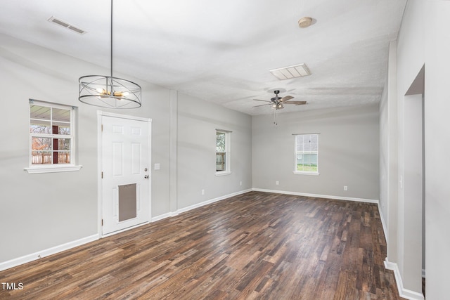 foyer entrance featuring dark wood-type flooring and ceiling fan with notable chandelier