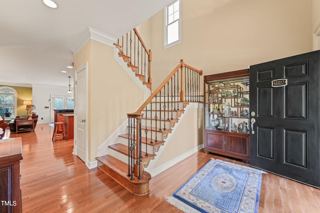 entryway featuring ornamental molding and hardwood / wood-style floors