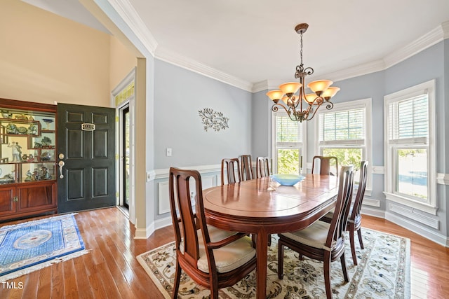 dining room featuring light hardwood / wood-style floors, an inviting chandelier, and ornamental molding