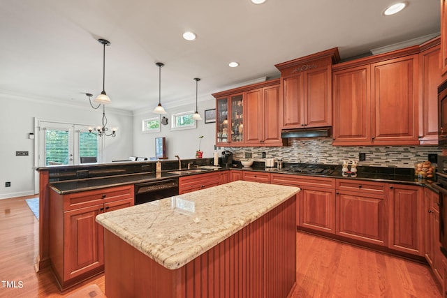 kitchen with kitchen peninsula, a center island, hanging light fixtures, and crown molding