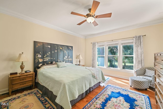 bedroom with crown molding, wood-type flooring, and ceiling fan