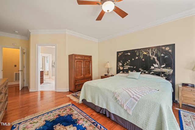 bedroom featuring ensuite bath, hardwood / wood-style flooring, ornamental molding, and ceiling fan