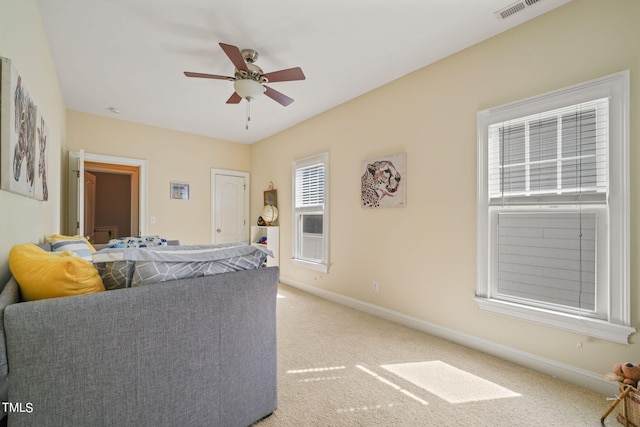 carpeted living room with ceiling fan