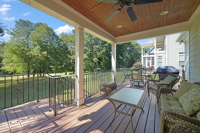 wooden deck with a yard and ceiling fan