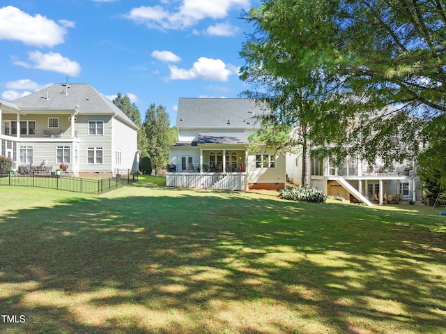 rear view of property featuring a wooden deck and a yard