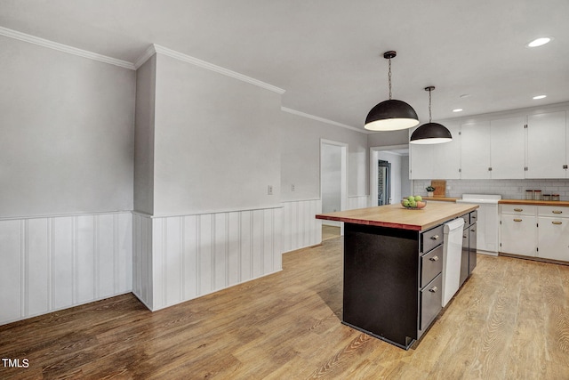 kitchen with light hardwood / wood-style floors, pendant lighting, a kitchen island, wood counters, and white cabinetry