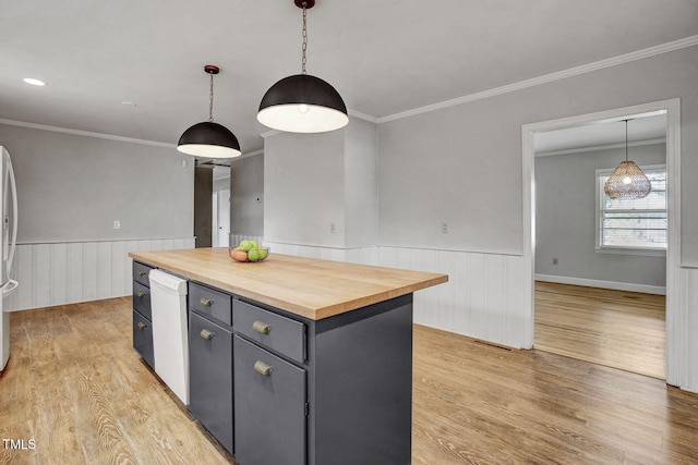 kitchen featuring crown molding, a kitchen island, light hardwood / wood-style flooring, decorative light fixtures, and butcher block counters