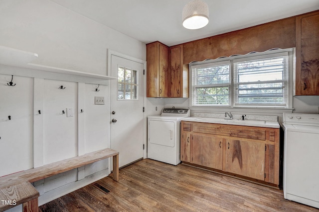 laundry room featuring washer / dryer, sink, light hardwood / wood-style floors, and cabinets