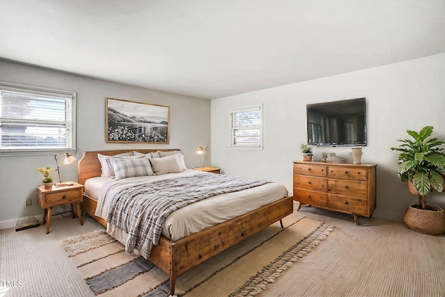 bedroom featuring light carpet and multiple windows