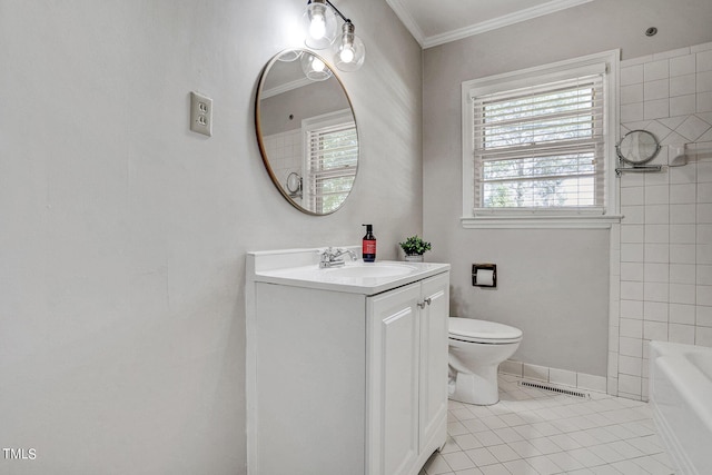 bathroom featuring a tub, vanity, toilet, and a wealth of natural light