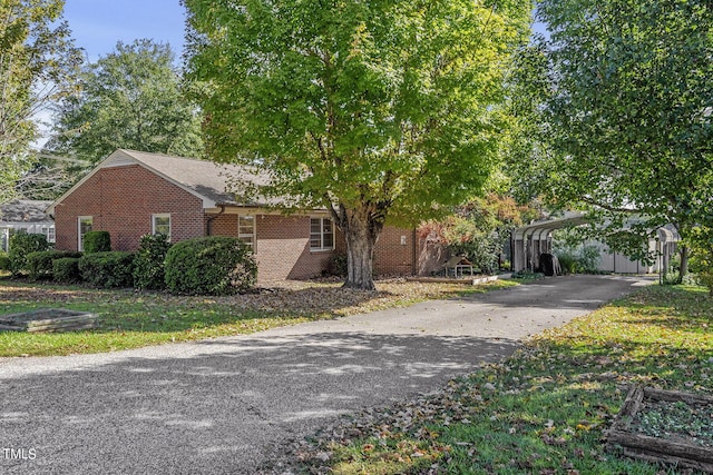 view of property hidden behind natural elements with a carport