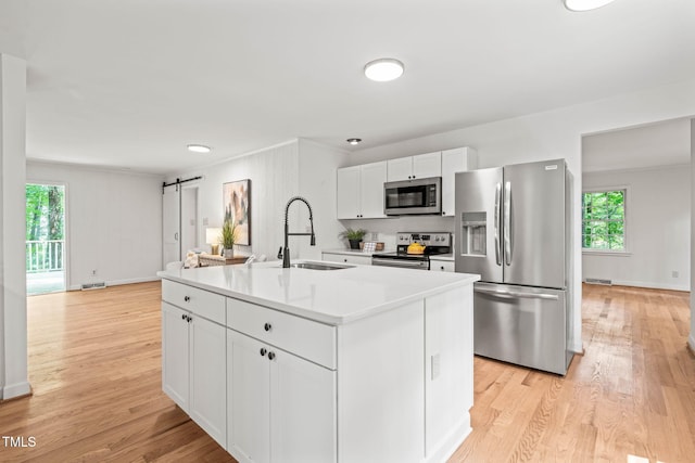 3006 Pump Station Ln, Durham, NC 27712 - kitchen featuring appliances with stainless steel finishes, white cabinetry, light wood finished floors, healthy amount of natural light, and crown molding