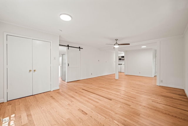 3006 Pump Station Ln, Durham, NC 27712 - unfurnished living room with a ceiling fan, light wood-style flooring, a barn door, and washer / clothes dryer