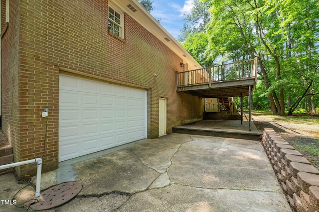 3006 Pump Station Ln, Durham, NC 27712 - view of home's exterior with concrete driveway, brick siding, a garage, and a wooden deck