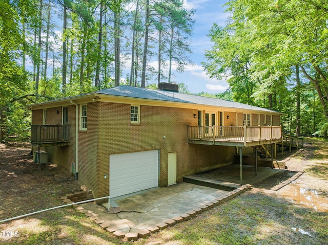 3006 Pump Station Ln, Durham, NC 27712 - rear view of property with an attached garage, a wooden deck, brick siding, and driveway