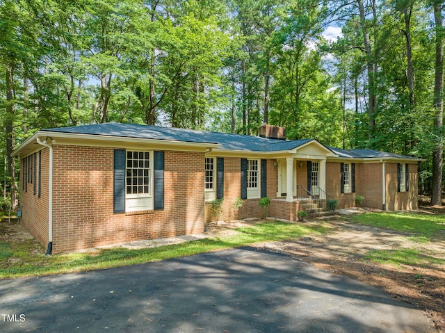 3006 Pump Station Ln, Durham, NC 27712 - ranch-style home featuring brick siding, a chimney, and view of wooded area