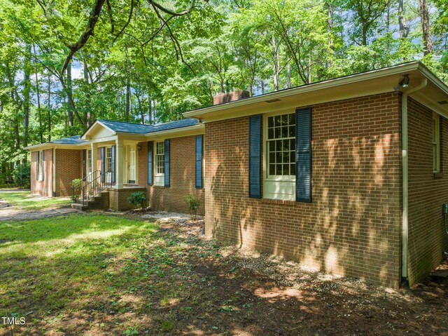3006 Pump Station Ln, Durham, NC 27712 - view of property exterior featuring brick siding, an attached garage, and a yard