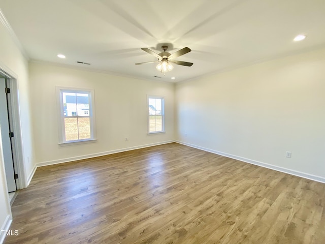 empty room with ornamental molding, ceiling fan, a healthy amount of sunlight, and wood-type flooring