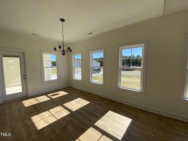 unfurnished dining area featuring dark wood-type flooring, a wealth of natural light, and crown molding