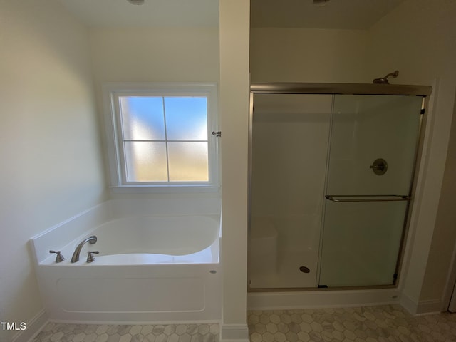 full bath with a stall shower, tile patterned floors, baseboards, and a bath