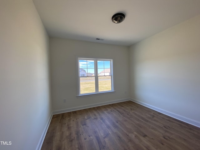 unfurnished room featuring dark wood finished floors and baseboards