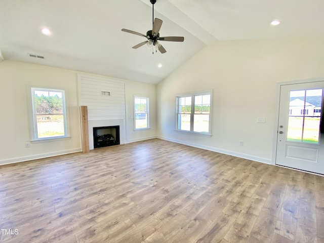 unfurnished living room featuring visible vents, a ceiling fan, a fireplace, beam ceiling, and wood finished floors