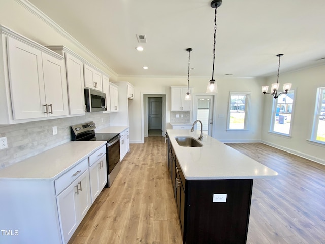 kitchen with backsplash, a sink, ornamental molding, and appliances with stainless steel finishes