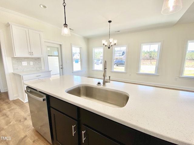 kitchen featuring a wealth of natural light, dishwasher, white cabinetry, and a sink