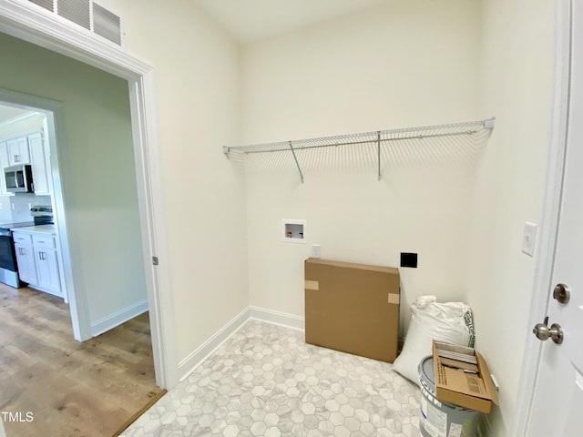 clothes washing area featuring visible vents, laundry area, baseboards, and light wood-style flooring