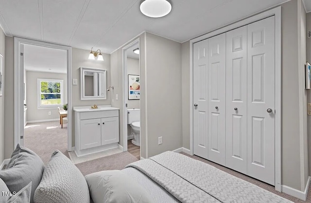 4193 Ji Oakes Rd, Bullock, NC 27507 - bedroom featuring baseboards, light colored carpet, connected bathroom, and a closet