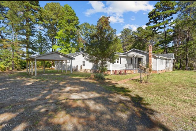 4193 Ji Oakes Rd, Bullock, NC 27507 - view of front facade with a carport, a porch, a front yard, a chimney, and dirt driveway