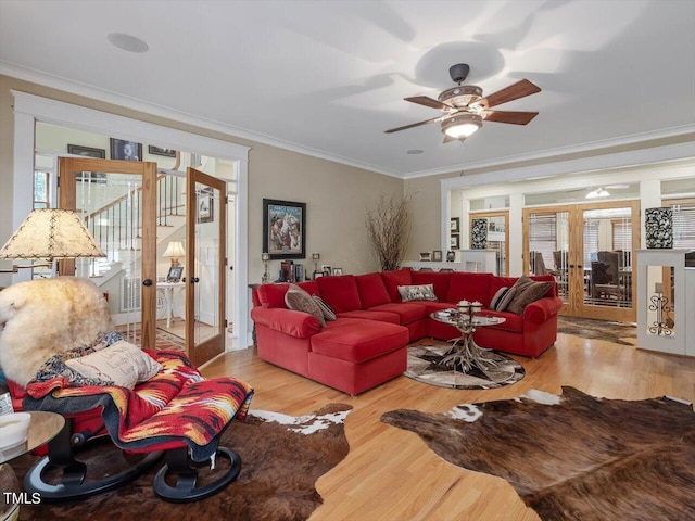 living room featuring french doors, ornamental molding, light wood-type flooring, and ceiling fan