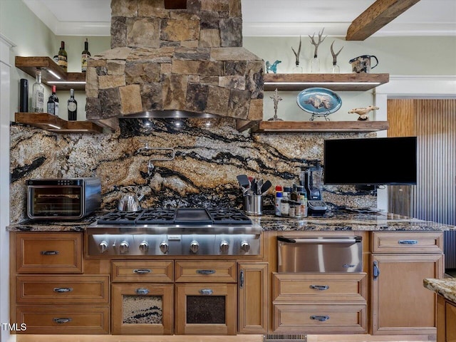 kitchen featuring ornamental molding, stainless steel gas stovetop, beamed ceiling, and dark stone counters