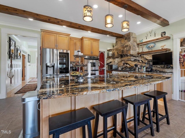 kitchen featuring beamed ceiling, dark stone countertops, stainless steel appliances, and hanging light fixtures