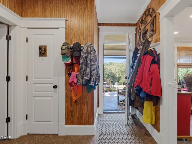 interior space with crown molding, wood walls, and tile patterned flooring