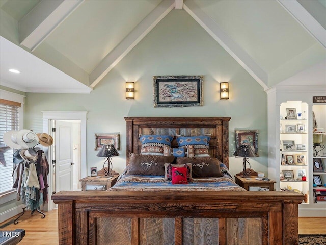 bedroom with light hardwood / wood-style floors, crown molding, and lofted ceiling