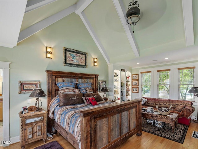 bedroom featuring beam ceiling, high vaulted ceiling, connected bathroom, light hardwood / wood-style flooring, and ornamental molding