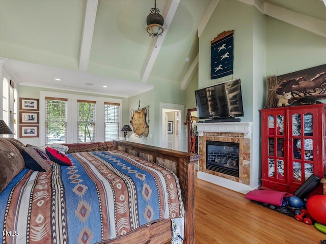 bedroom featuring light hardwood / wood-style flooring, lofted ceiling with beams, crown molding, and ceiling fan