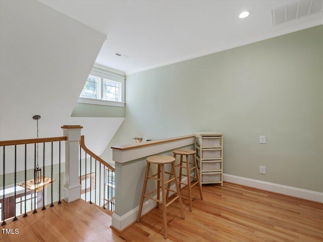 staircase featuring crown molding and hardwood / wood-style flooring