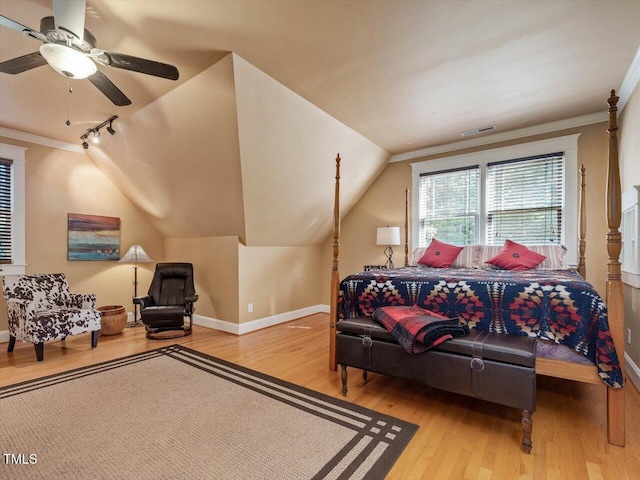 bedroom featuring light hardwood / wood-style floors, lofted ceiling, crown molding, and ceiling fan