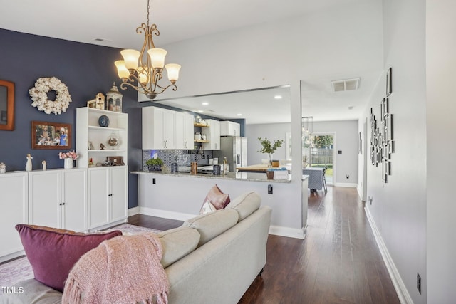 living room featuring an inviting chandelier and dark hardwood / wood-style flooring