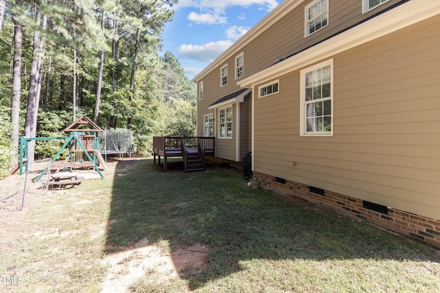 view of yard with a playground and a deck